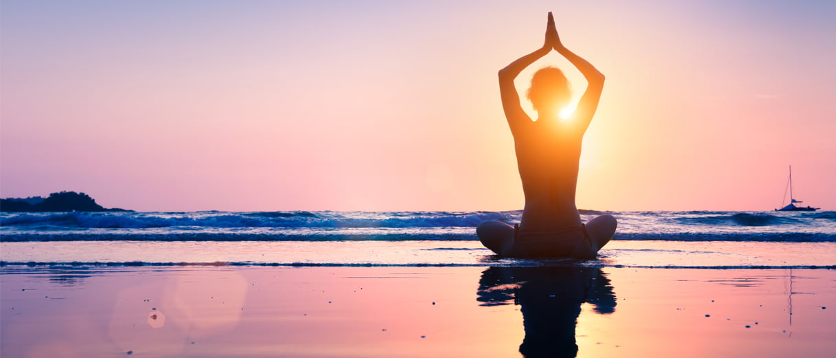 Person doing yoga as the sun rises