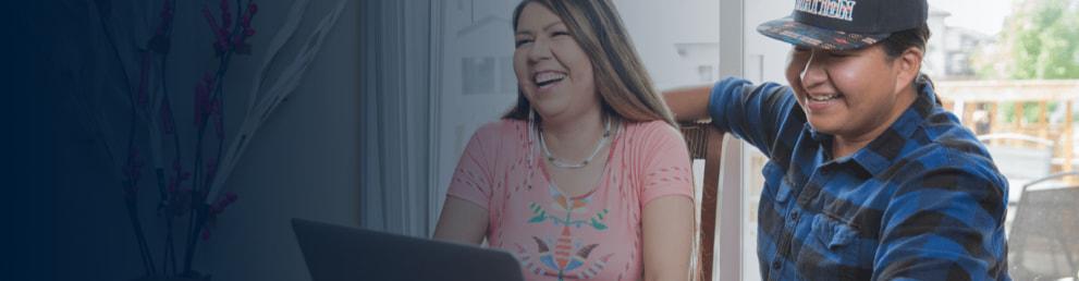 Two Indigenous women laughing together.