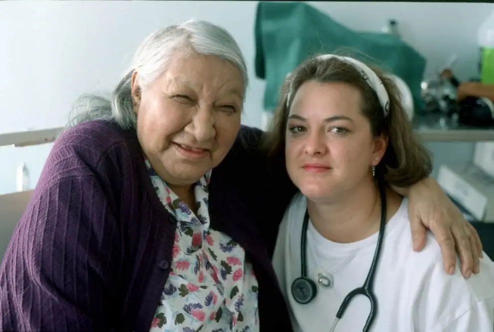 Femme autochtone entourant de son bras une professionnelle de la santé. 