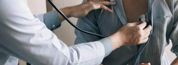Professionnel de la santé autochtone posant un stéthoscope sur le thorax d’un patient